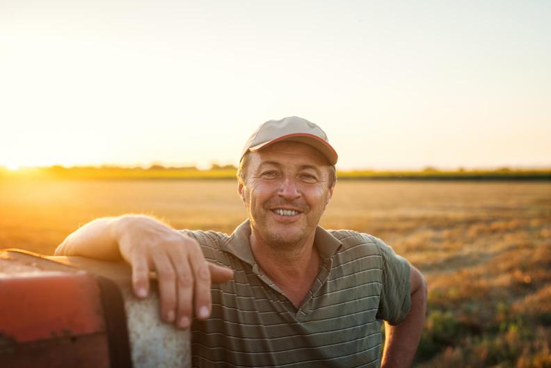 Farmer posing in front of field