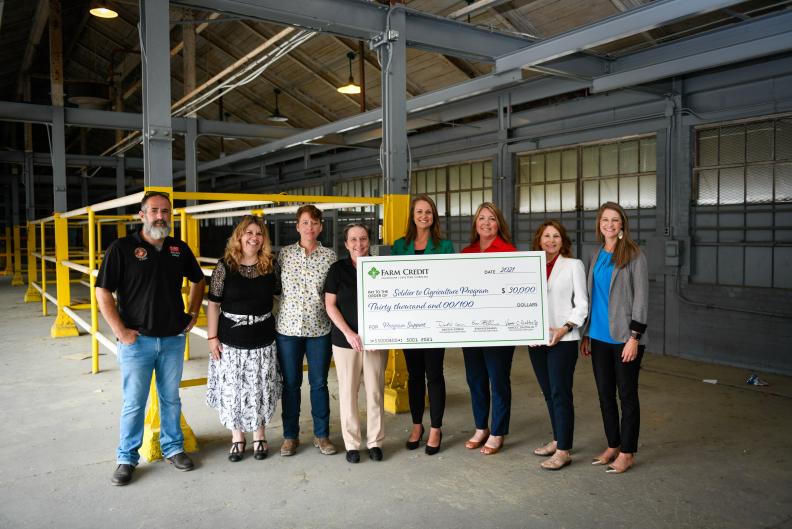 Group posing with large check